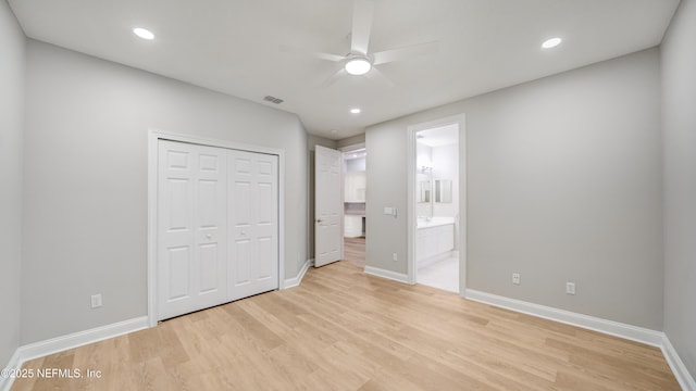 unfurnished bedroom with connected bathroom, light wood-type flooring, a closet, and ceiling fan