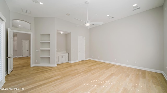 interior space with built in shelves, light hardwood / wood-style floors, and ceiling fan