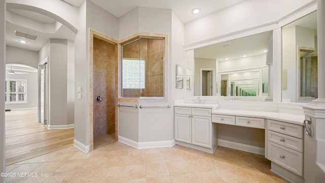 bathroom with tile patterned flooring, vanity, plenty of natural light, and tiled shower