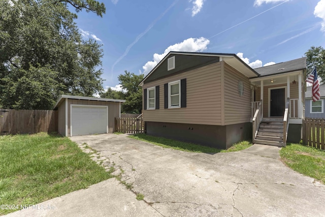 view of front of property featuring an outbuilding, a garage, and a front lawn