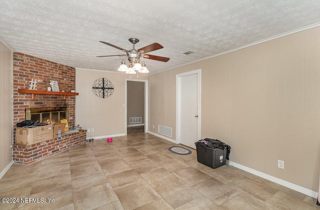 unfurnished living room with light tile patterned floors, a brick fireplace, ceiling fan, and crown molding