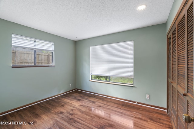 unfurnished bedroom with multiple windows, a closet, and a textured ceiling