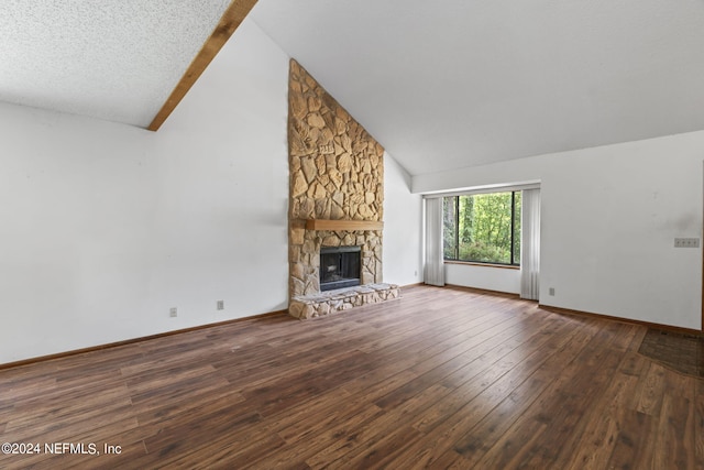 unfurnished living room featuring vaulted ceiling, a stone fireplace, and dark hardwood / wood-style flooring