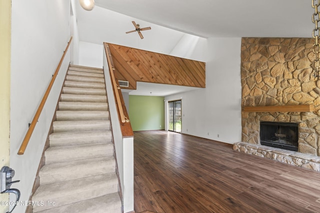 interior space with a stone fireplace, high vaulted ceiling, and hardwood / wood-style flooring