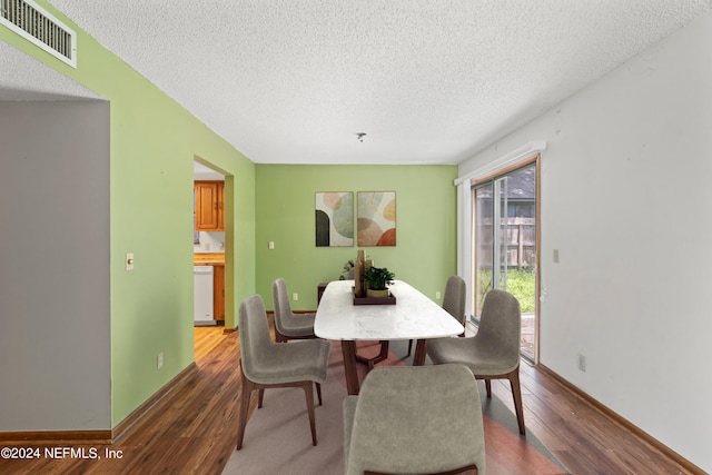 dining area with hardwood / wood-style floors and a textured ceiling