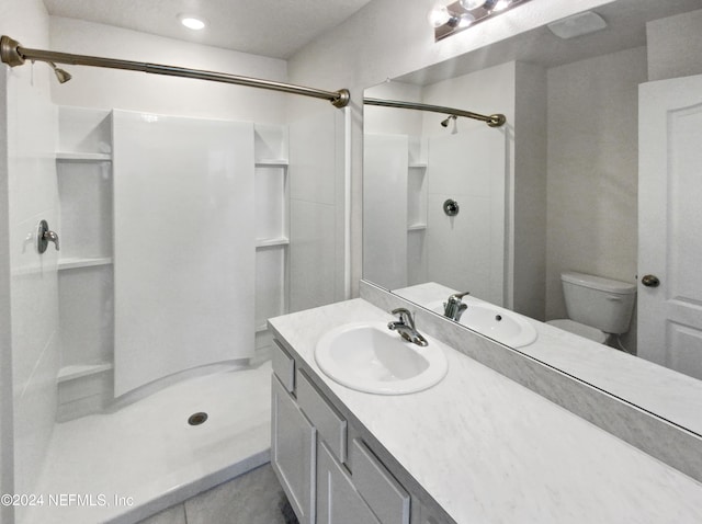 bathroom with toilet, a shower, and vanity