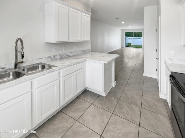 kitchen featuring sink, light tile patterned floors, black electric range oven, kitchen peninsula, and white cabinets