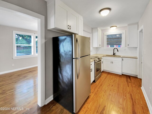 kitchen featuring sink, white cabinetry, light wood-type flooring, and stainless steel appliances