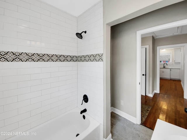 bathroom featuring hardwood / wood-style flooring, sink, and tiled shower / bath