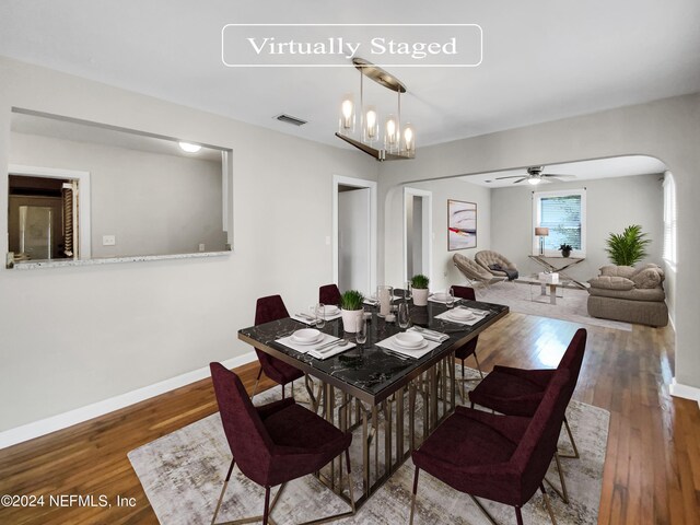 dining room featuring dark hardwood / wood-style floors and ceiling fan with notable chandelier