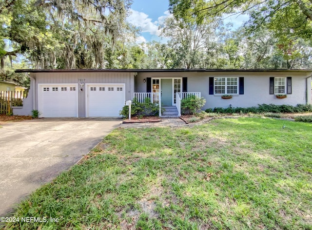 ranch-style house with a porch, a garage, and a front yard