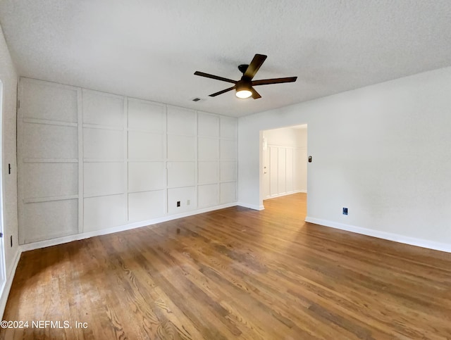 unfurnished room featuring wood-type flooring, a textured ceiling, and ceiling fan