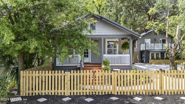 view of front facade featuring covered porch and a fenced front yard