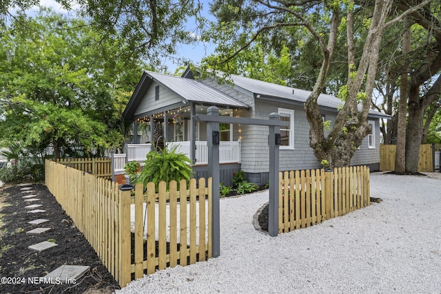 view of front of home with a fenced front yard and a porch