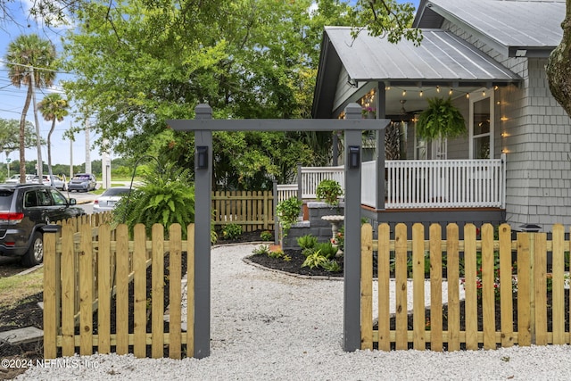 view of gate featuring a porch and a fenced front yard