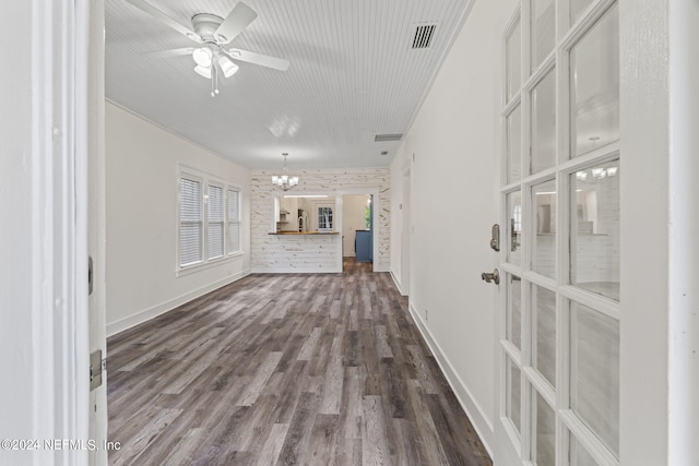 unfurnished living room with ceiling fan with notable chandelier, visible vents, baseboards, and wood finished floors