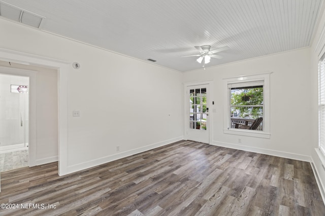 unfurnished room with a ceiling fan, dark wood-style flooring, visible vents, and baseboards