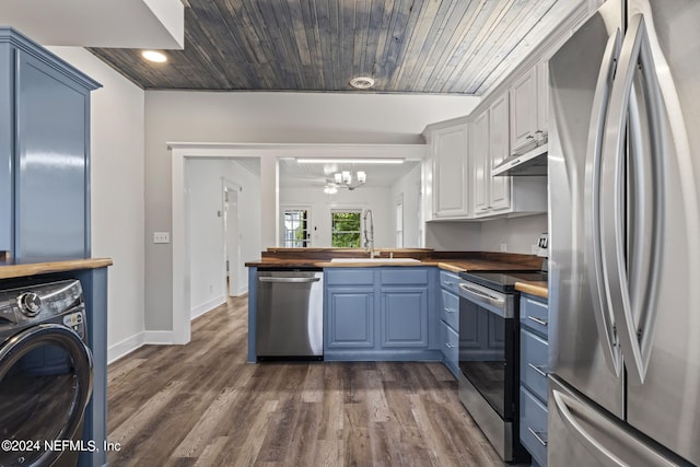 kitchen featuring wooden counters, appliances with stainless steel finishes, a sink, washer / dryer, and under cabinet range hood