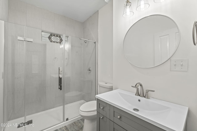 bathroom featuring a stall shower, vanity, and toilet