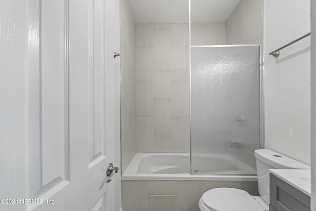 full bathroom with toilet, shower / bath combination with glass door, and vanity