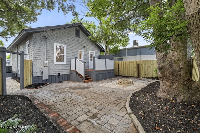 back of house with an outdoor fire pit, a patio area, and fence