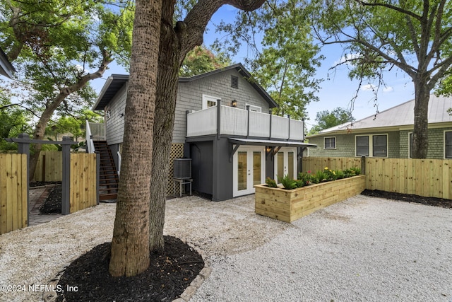 rear view of property with stairs, fence, cooling unit, and french doors