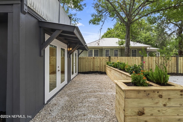 view of yard with fence and french doors