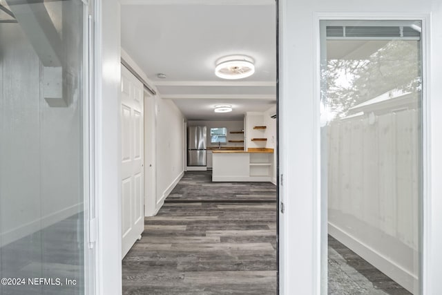 corridor with dark wood finished floors and baseboards