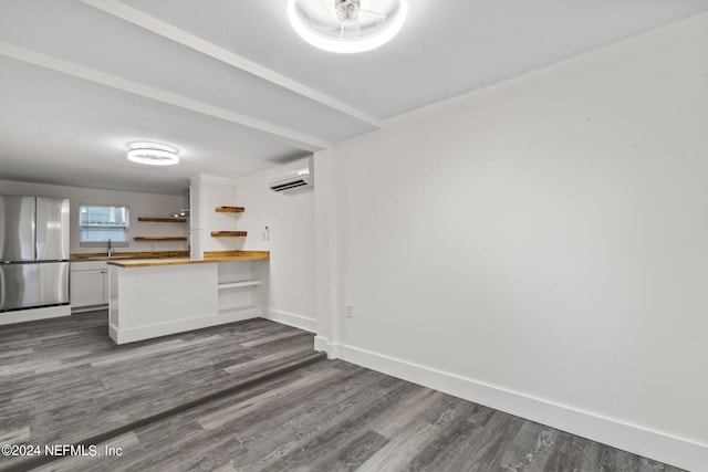 kitchen featuring open shelves, butcher block counters, freestanding refrigerator, white cabinetry, and a wall mounted air conditioner