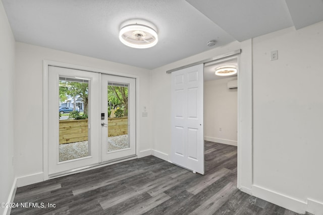 entryway featuring dark wood-style floors, baseboards, an AC wall unit, and french doors