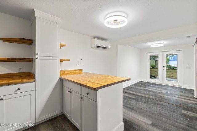 kitchen with a wall unit AC, wood counters, white cabinets, and open shelves