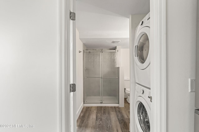 washroom with stacked washer / dryer, laundry area, and dark wood finished floors