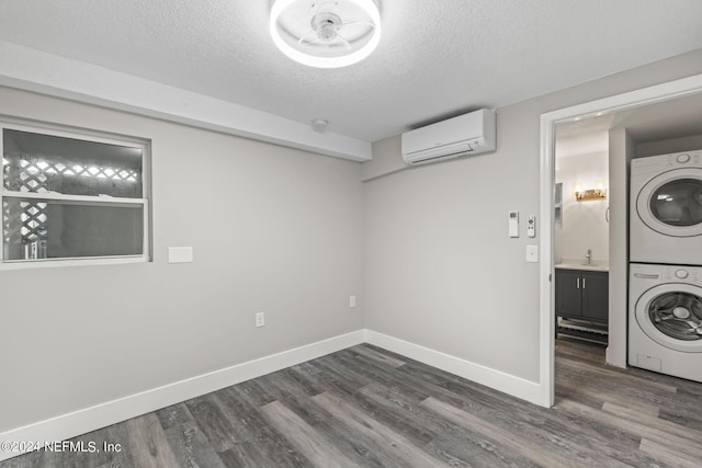 washroom featuring stacked washer / dryer, dark wood finished floors, a textured ceiling, and a wall mounted AC