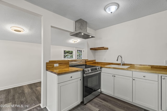 kitchen with electric stove, white cabinets, a sink, wall chimney range hood, and butcher block countertops