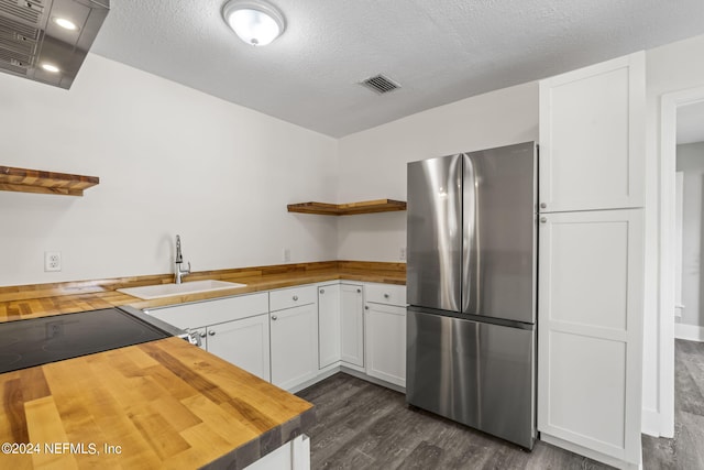 kitchen with wood counters, visible vents, white cabinets, freestanding refrigerator, and open shelves