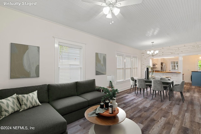 living room featuring ceiling fan with notable chandelier and wood finished floors