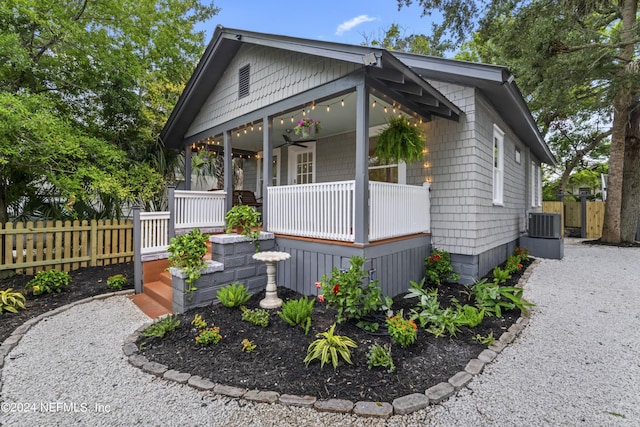 view of front of house featuring a porch, ceiling fan, driveway, and fence