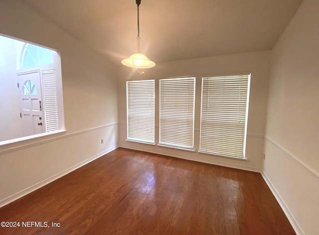 spare room featuring vaulted ceiling and dark hardwood / wood-style floors