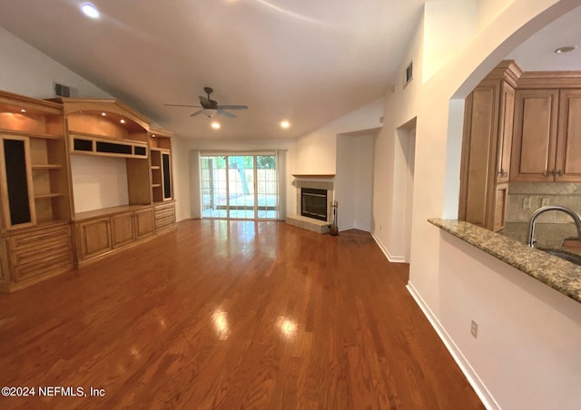 unfurnished living room with vaulted ceiling, ceiling fan, and dark wood-type flooring