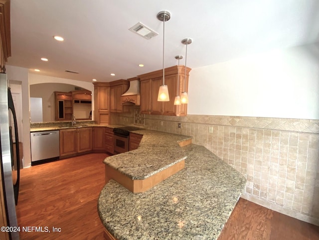 kitchen featuring decorative light fixtures, kitchen peninsula, stainless steel appliances, and custom range hood