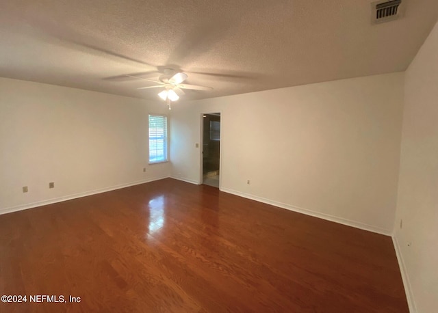 unfurnished room featuring a textured ceiling, ceiling fan, and dark wood-type flooring