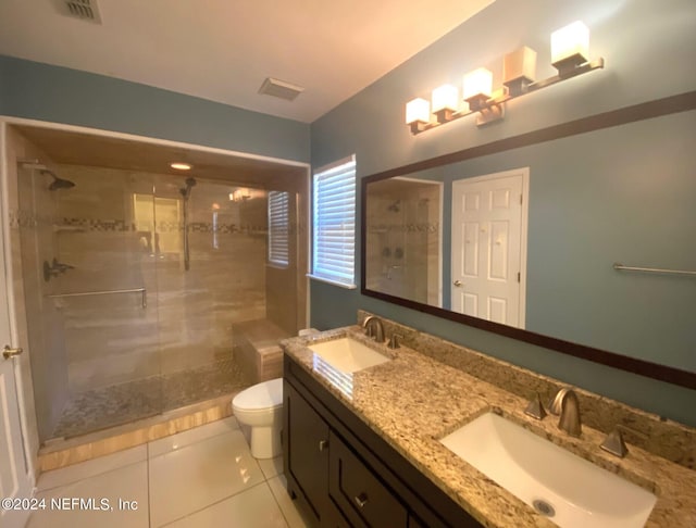 bathroom featuring tile patterned flooring, vanity, a shower with door, and toilet