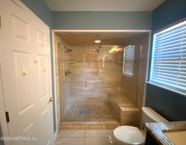 bathroom with tile patterned floors, vanity, a shower with shower door, and toilet