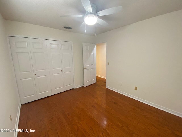 unfurnished bedroom featuring ceiling fan, a closet, and dark hardwood / wood-style floors