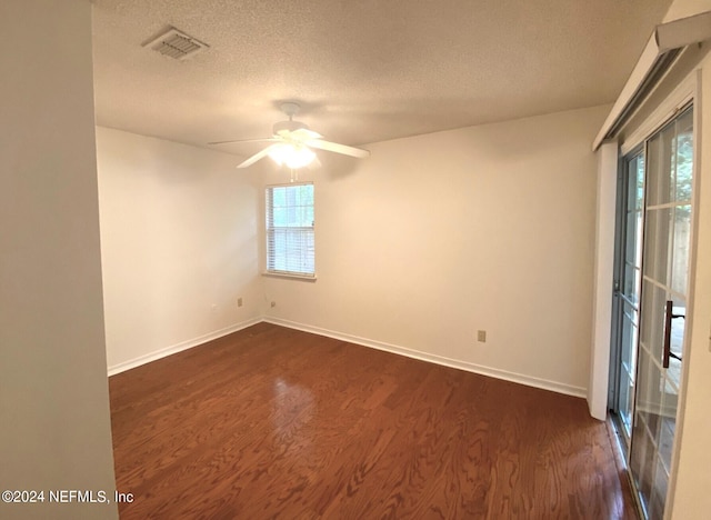 spare room with a textured ceiling, dark hardwood / wood-style floors, and ceiling fan