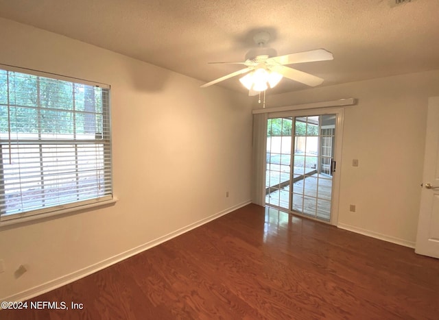 spare room with ceiling fan, dark wood-type flooring, and a textured ceiling