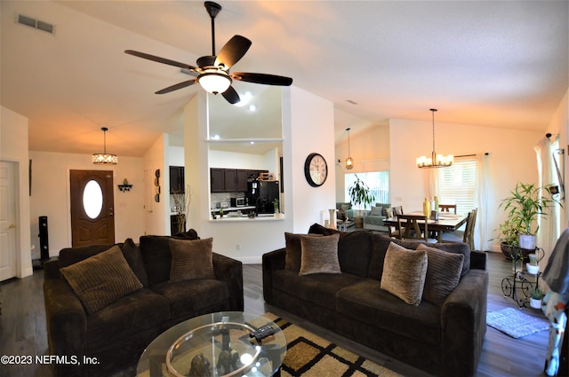 living room featuring dark hardwood / wood-style flooring, ceiling fan with notable chandelier, and vaulted ceiling