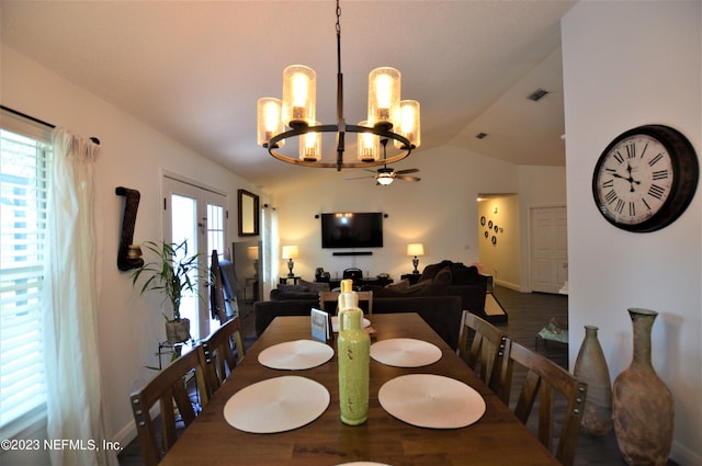 dining room featuring wood-type flooring, ceiling fan with notable chandelier, vaulted ceiling, and french doors