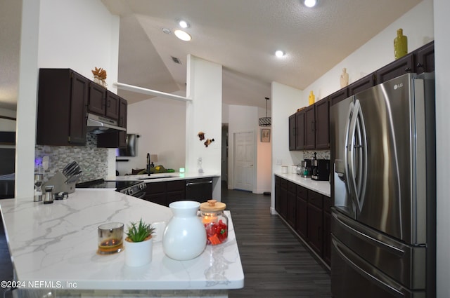 kitchen featuring light stone countertops, sink, stainless steel appliances, kitchen peninsula, and decorative backsplash