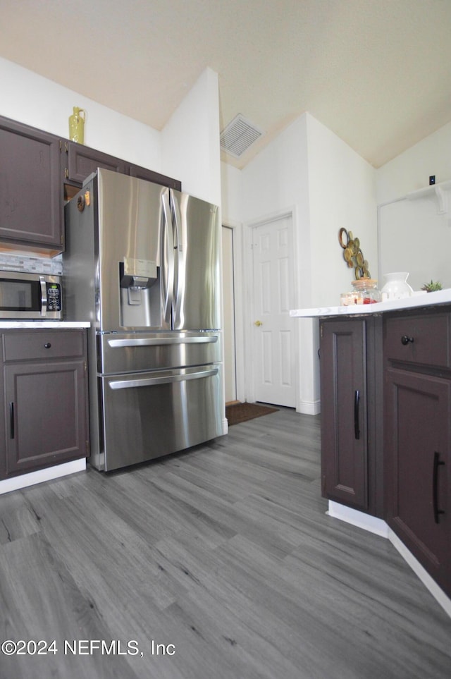 kitchen with dark brown cabinetry, lofted ceiling, dark hardwood / wood-style floors, and appliances with stainless steel finishes